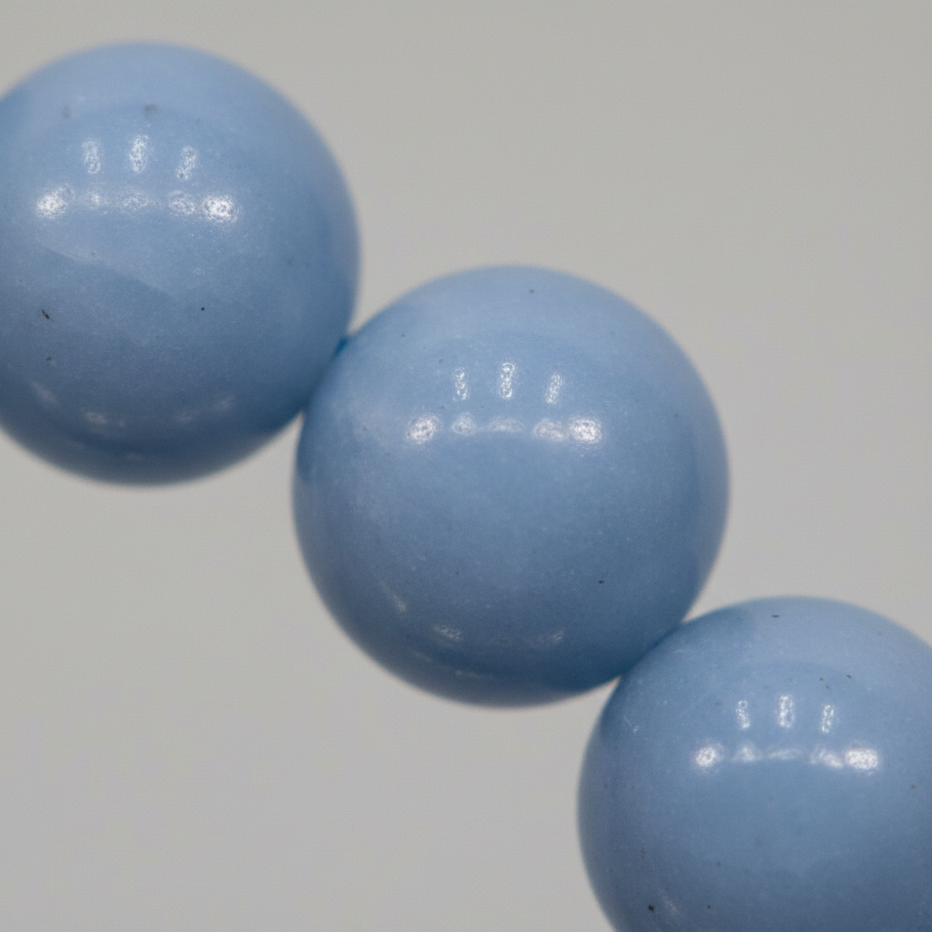 Close-up of Angelite 8mm bracelet beads showing soft powder blue stone surface with smooth matte finish — Prana Blessings