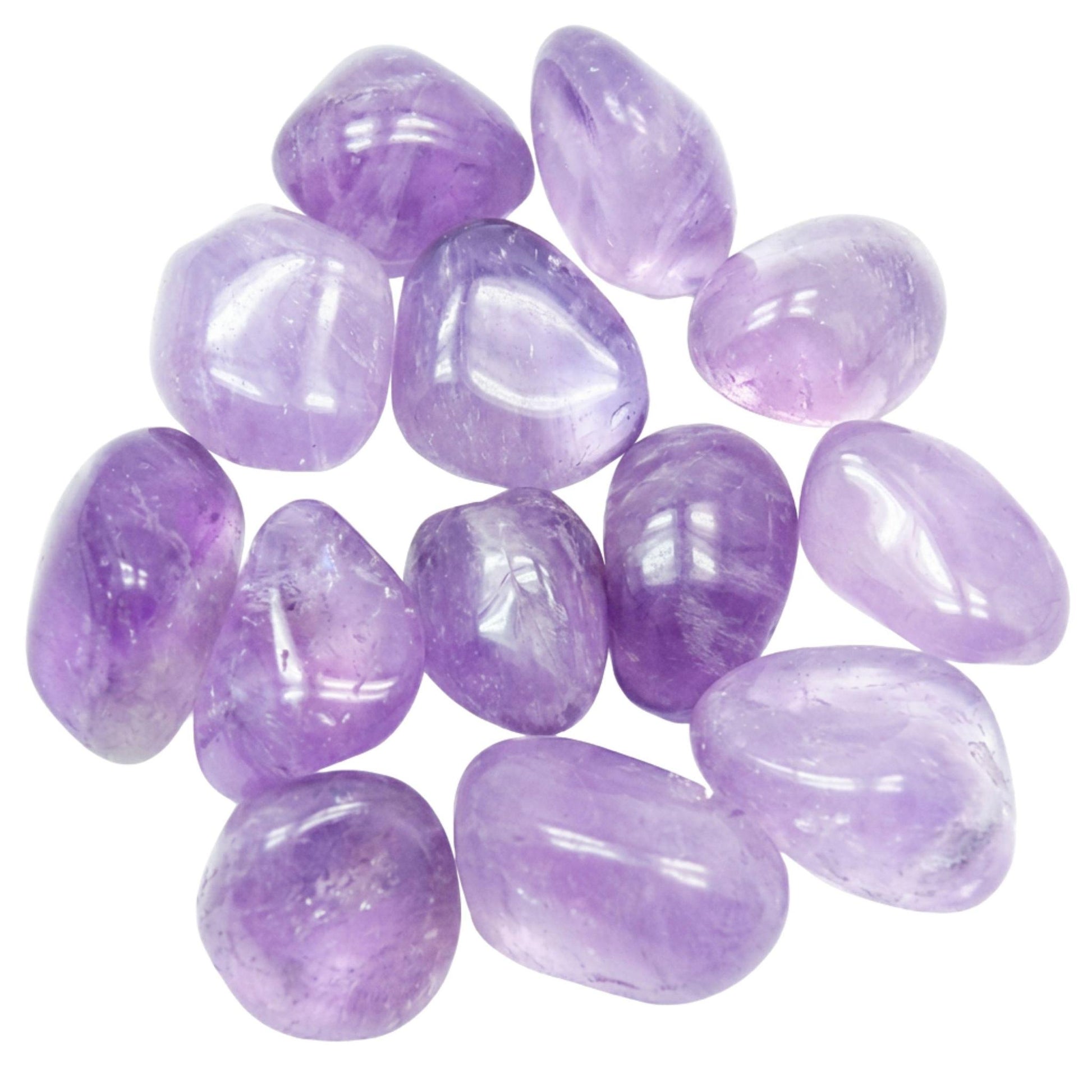 A pile of polished tumbled purple amethyst gemstones on a plain white background.