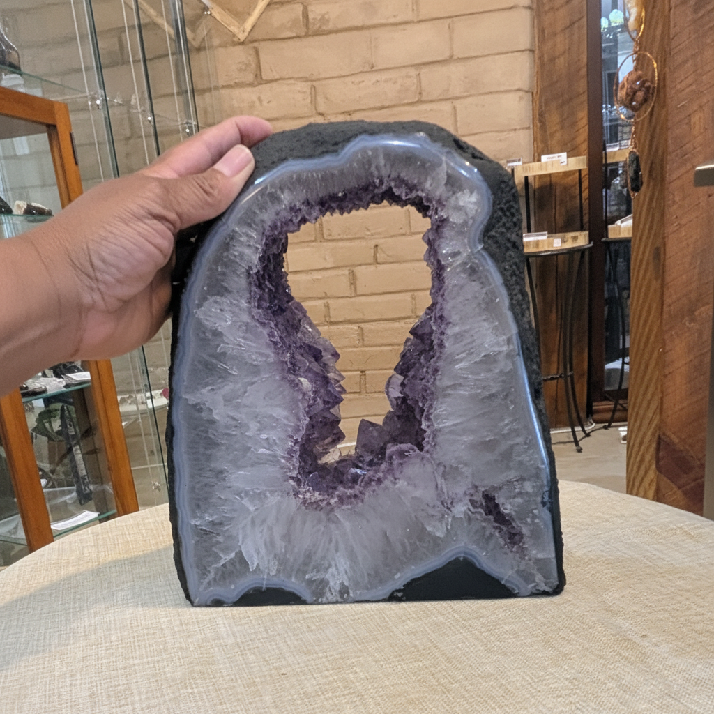 Natural Amethyst Window Cathedral with polished display face held in hand to show approximate scale