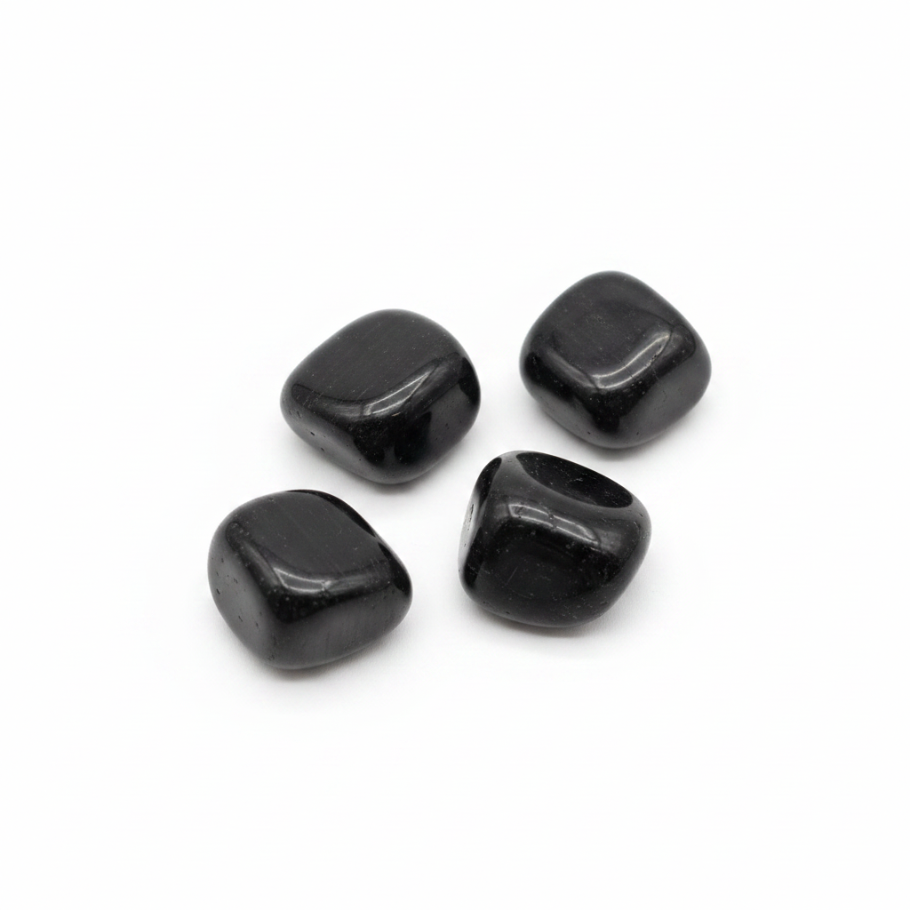 Polished black tourmaline tumbled stones arranged on a clean white background.