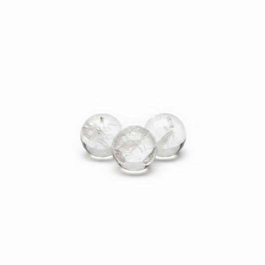 Mini polished Clear Quartz spheres on a clean light background