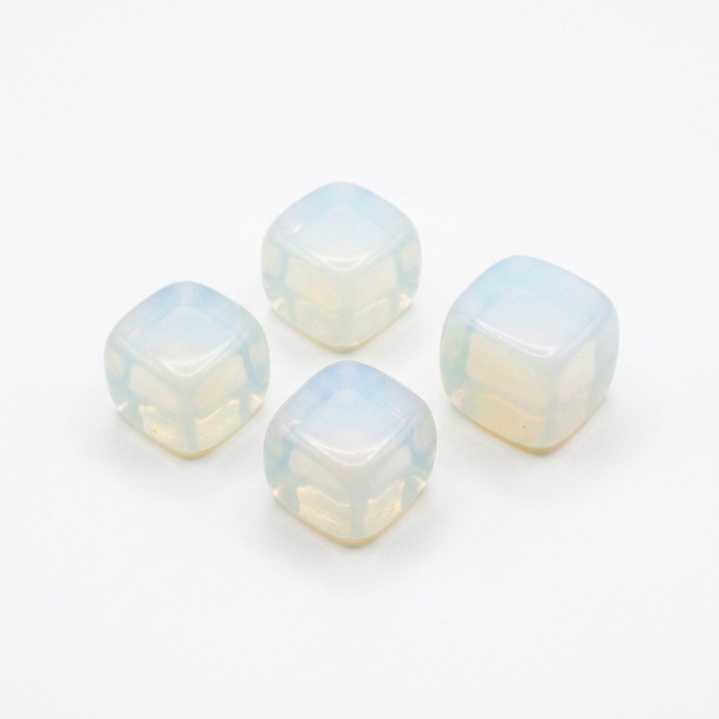 Four square opalite tumbled stones with a milky, iridescent opal-like finish, arranged on a plain white background.