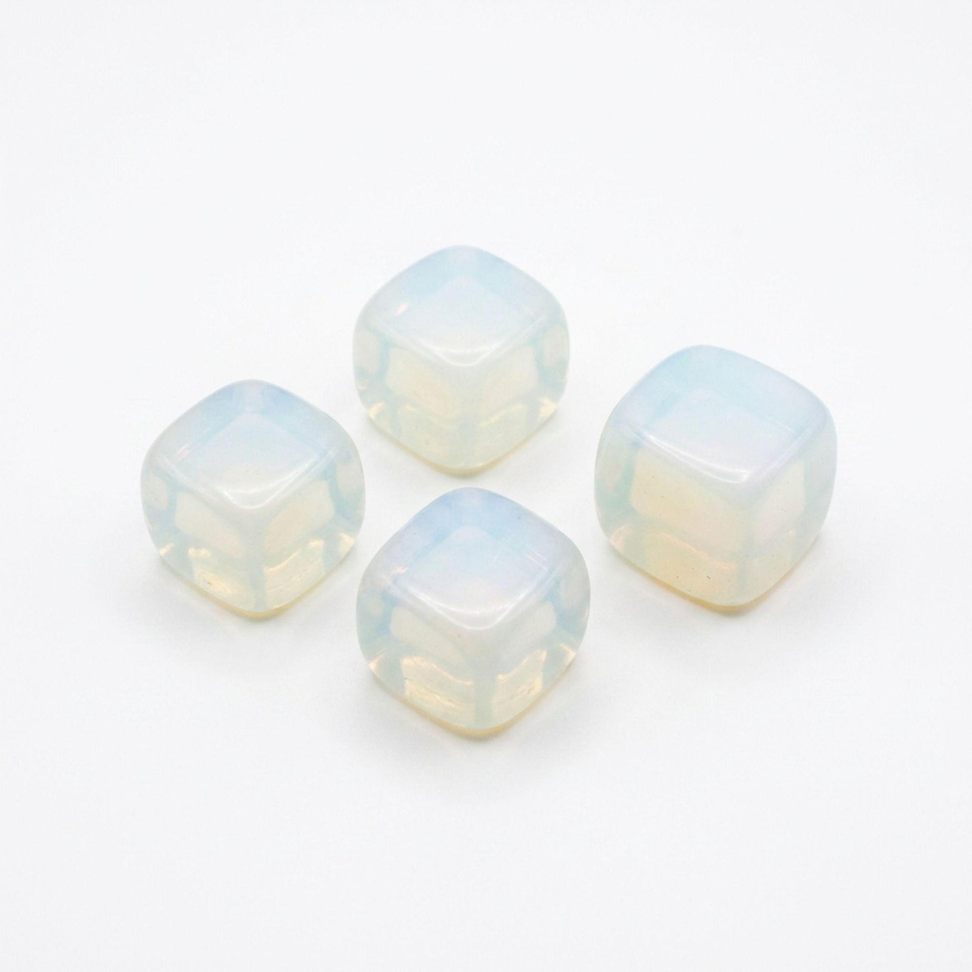 Four square opalite tumbled stones with a milky, iridescent opal-like finish, arranged on a plain white background.