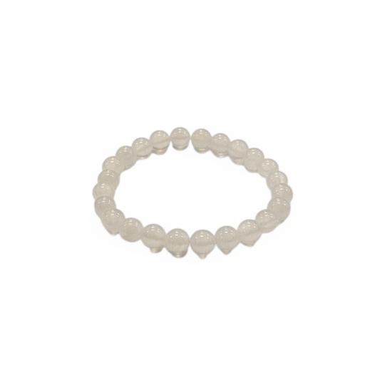 Selenite 8mm stretch bracelet with luminous white beads on a white background