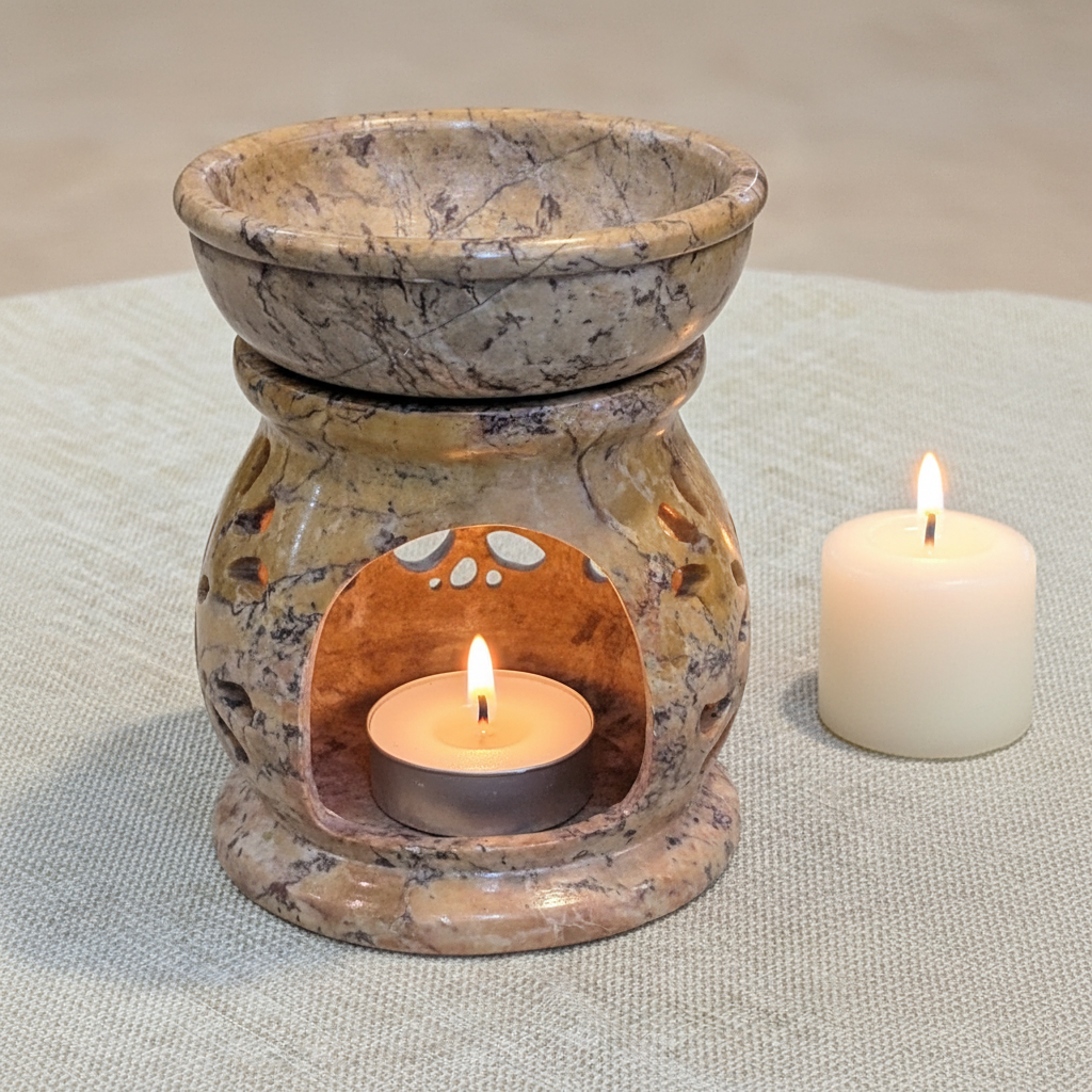 Tree of Life soapstone aroma oil burner lit from the front in a styled setting