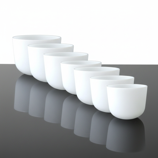Seven-piece Soundtopia frosted quartz crystal singing bowl set arranged by size on white background